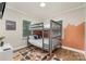 Bedroom with bunk beds, hardwood floors, a mounted television, and a mountain-themed mural at 2601 Ashley Rd, Charlotte, NC 28208