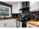 Modern kitchen with stainless steel appliances, black countertop with black range and white cabinets at 2601 Ashley Rd, Charlotte, NC 28208