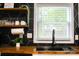 Close up of black faucet and stylish accents on floating shelves above wood countertops at 2601 Ashley Rd, Charlotte, NC 28208