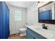 Charming bathroom with blue vanity, updated fixtures, and patterned wallpaper at 2903 Price Rushing Rd, Monroe, NC 28110