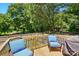 Outdoor deck with cushioned chairs and a wooded backyard view at 2903 Price Rushing Rd, Monroe, NC 28110