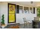 Up close view of a bright yellow door with a wreath and quaint seating area offering a cheerful and welcoming entrance at 2903 Price Rushing Rd, Monroe, NC 28110