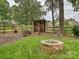 Backyard featuring a wood storage area, fire pit and mature landscaping at 2911 Butter Churn Ln, Matthews, NC 28105
