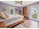 Stylish bedroom featuring hardwood floors, two windows, a ceiling fan, and lilac colored walls at 2911 Butter Churn Ln, Matthews, NC 28105