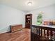 Sunlit bedroom with hardwood floors, a window, and light blue walls at 2911 Butter Churn Ln, Matthews, NC 28105