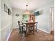 Cozy dining area with wood table, four chairs, and a wall-mounted TV at 2911 Butter Churn Ln, Matthews, NC 28105