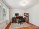 Well-lit home office featuring hardwood floors, a large window, and built-in shelving at 2911 Butter Churn Ln, Matthews, NC 28105