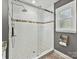 Shower with mosaic tiled accent stripe, a glass door and a shower head at 2911 Butter Churn Ln, Matthews, NC 28105