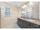 Bathroom featuring double sinks with granite countertops and a large mirror at 3039 Potomac River Pkwy, Charlotte, NC 28217