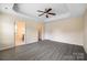 Bedroom featuring a ceiling fan, neutral walls, and a view into the Primary bath at 3039 Potomac River Pkwy, Charlotte, NC 28217