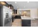 Open kitchen with stainless steel appliances, granite countertops, dark cabinets and view of dining area at 3039 Potomac River Pkwy, Charlotte, NC 28217