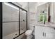 Modern bathroom with walk-in shower, granite countertop, white cabinets, and stylish fixtures at 3058 Tramore Dr, Harrisburg, NC 28075