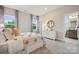 Cozy bedroom with patterned bedding, dresser, and window views and ensuite bathroom at 3058 Tramore Dr, Harrisburg, NC 28075