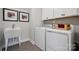 Well-organized laundry room featuring modern washer and dryer with white cabinets and stylish decor at 3058 Tramore Dr, Harrisburg, NC 28075