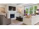Cozy living room with a fireplace, built-in shelving, and large window for ample natural light at 3058 Tramore Dr, Harrisburg, NC 28075