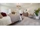 Bright and airy main bedroom with neutral tones, showcasing a comfortable seating area and modern decor at 3058 Tramore Dr, Harrisburg, NC 28075