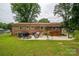 The backyard features a brick home, a patio with a bar, lounge chairs and an expansive lawn at 3424 Autumn Dr, Gastonia, NC 28056