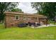 Expansive backyard featuring a brick home, patio area, a grill, and well-maintained lawn at 3424 Autumn Dr, Gastonia, NC 28056