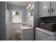 Bathroom featuring decorative window treatment, white cabinets, and washer and dryer at 3424 Autumn Dr, Gastonia, NC 28056