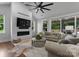Spacious living room featuring a brick fireplace, large television, and access to backyard patio at 4021 Redwood Ave, Charlotte, NC 28205