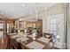 Elegant dining room with chandelier, table set for eight, and open floor plan at 4430 Bravery Sw Pl, Concord, NC 28027