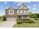 Charming two-story home with a brick and siding exterior, manicured lawn, and mature landscaping at 4430 Bravery Sw Pl, Concord, NC 28027