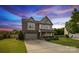 Two-story home featuring a brick facade, two-car garage, well-manicured lawn, and lush landscaping at 4430 Bravery Sw Pl, Concord, NC 28027