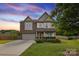 Charming two-story home with a manicured lawn, a two-car garage, and a combination of brick and siding at 4430 Bravery Sw Pl, Concord, NC 28027
