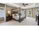 Spacious main bedroom featuring a four poster bed, large windows, and soft carpet at 4430 Bravery Sw Pl, Concord, NC 28027