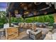 Outdoor kitchen with bar seating, hot tub, grill and manicured landscaping at 4430 Bravery Sw Pl, Concord, NC 28027