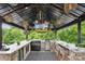 Outdoor kitchen features a grill, beverage cooler, and a bar with seating and adjacent landscaping at 4430 Bravery Sw Pl, Concord, NC 28027
