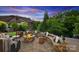 Stone patio featuring a fire pit and seating area with an umbrella table and wooded backdrop at 4430 Bravery Sw Pl, Concord, NC 28027