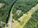Beautiful aerial view of property, featuring lush greenery, mature trees, and a serene natural setting with nearby pond at 5033 Waxhaw Indian Trail Rd, Matthews, NC 28104