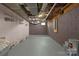 Unfinished basement with gray painted walls, visible pipes, and concrete floor, offering potential for customization at 5033 Waxhaw Indian Trail Rd, Matthews, NC 28104