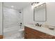 A bathroom featuring a marble tiled shower, a wooden vanity with a white countertop and hardwood floors at 5033 Waxhaw Indian Trail Rd, Matthews, NC 28104