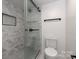 A bathroom featuring a glass enclosed shower with marble tile and a white toilet at 5033 Waxhaw Indian Trail Rd, Matthews, NC 28104