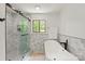 Bright bathroom with a glass shower, a modern tub, and views of the nature at 5033 Waxhaw Indian Trail Rd, Matthews, NC 28104