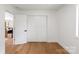 A bedroom featuring hardwood floors, white walls, an open doorway and a closet at 5033 Waxhaw Indian Trail Rd, Matthews, NC 28104