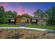 Stunning single-story home with a modern design and inviting walkway, surrounded by lush greenery and mature trees at 5033 Waxhaw Indian Trail Rd, Matthews, NC 28104