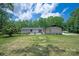 Exterior of the house with a green lawn, mature trees, long driveway and patio at 5033 Waxhaw Indian Trail Rd, Matthews, NC 28104