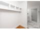 A hallway with hardwood floors and built-in shelves leading to a tiled bathroom at 5033 Waxhaw Indian Trail Rd, Matthews, NC 28104