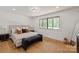 Serene bedroom features a large window, neutral tones, and hardwood floors at 5033 Waxhaw Indian Trail Rd, Matthews, NC 28104