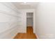 A pantry with wire shelves and a view into another room through an open door, with hardwood floors at 5033 Waxhaw Indian Trail Rd, Matthews, NC 28104
