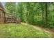 Expansive backyard featuring a wooden deck, lush landscaping, and a peaceful wooded backdrop at 530 Shady Oaks Dr, Stanley, NC 28164