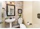 Half bath featuring mosaic tile accents, a pedestal sink, and elegant fixtures at 530 Shady Oaks Dr, Stanley, NC 28164