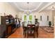 Formal dining room featuring hardwood floors, modern chandelier, a decorative buffet, and large windows overlooking the backyard at 530 Shady Oaks Dr, Stanley, NC 28164