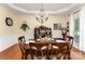 Formal dining room with hardwood floors, a decorative chandelier, and a view of the back yard through a large sunny window at 530 Shady Oaks Dr, Stanley, NC 28164