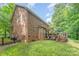 Rear exterior view of a brick home featuring a spacious yard and a deck, ideal for outdoor enjoyment at 530 Shady Oaks Dr, Stanley, NC 28164