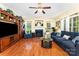 Bright living room boasts hardwood floors, a fireplace, and lots of natural light from the many windows with decorative white curtains at 530 Shady Oaks Dr, Stanley, NC 28164