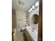 Well-lit bathroom featuring a tiled shower, a round mirror, and storage shelves for organization at 5734 Brookhaven Rd, Charlotte, NC 28210